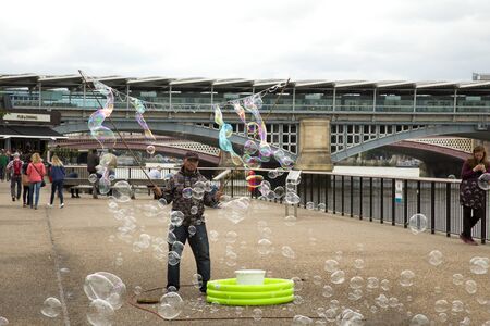 LONDON, UK - JUNE 5, 2017: Man doing giant soap bubbles as a living on the queen's walk in London, UKのeditorial素材