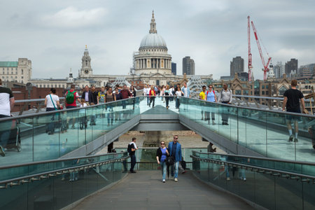 LONDON, UK - MAY 29 , 2017:  Tourists walking across the Millennium bridge to St. Paul Cathedral by...