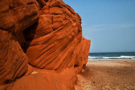 Red cliff in Havre aux maisons with waves in the ocean in the St-Lawrence golfe