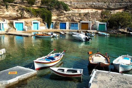 Fishing boats floating on turquoise water at Mandrakia in Milos Island in Cyclades in Greeceの写真素材