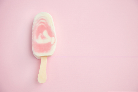 Berry sorbet and yogurt ice lolly with raspberry on a pale pink backgroundの写真素材