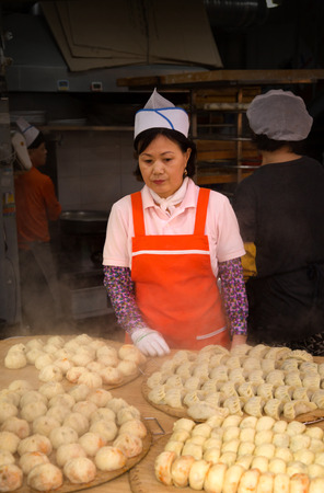 SEOUL-SOUTH KOREA, MAY 17, 2018: Woman selling dumpling in a food stand in Namdaemun Market in South Korea, the oldest and largest market in Koreaのeditorial素材