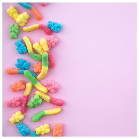 Different gummy candies on a pink background with white frame