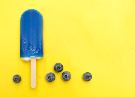Blueberry popsicle with fresh blueberry on a yellow  backgroundの写真素材