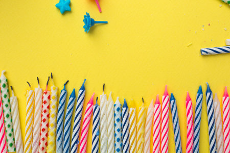 Burned candles and holder on a yellow background after a huge birthday party