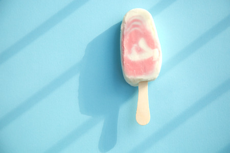 Berry sorbet and yogurt ice lolly with raspberry on a pale blue backgroundの写真素材