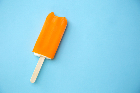 orange ice lolly on a blue backgroundの写真素材