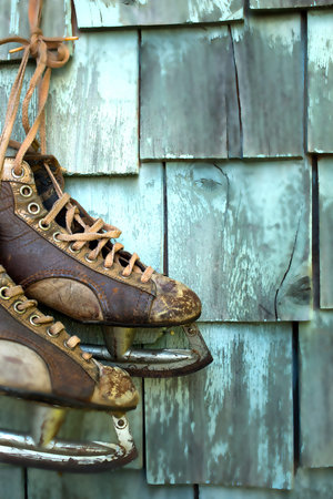 Old skates hanging on a greenish grungy wall