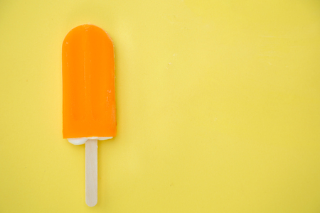 orange ice cream on a yellow backgroundの写真素材