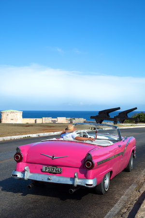 HAVANA-CUBA- DEC 4, 2018:  A classic convertible American vintage car in pink in Havana in Cuba.  They are very pride in having survived an era of no spare car parts and protecting their beauties.のeditorial素材