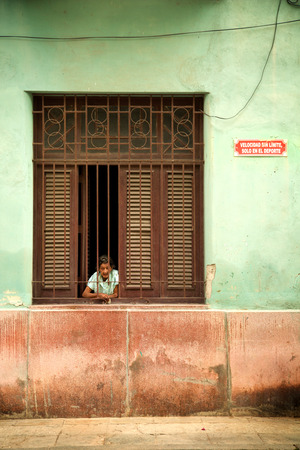 HAVANA-CUBA- DEC 5, 2018: Woman looking by her window in Centro Habana, one of the 15 municipalities or boroughs in the city of Havana, Cuba.のeditorial素材