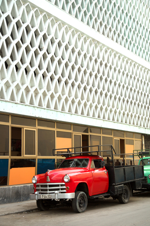 HAVANA-CUBA- DEC 5, 2018:  A classic American vintage pick up in red and colonial architectural building in Old Havana in Cubaのeditorial素材
