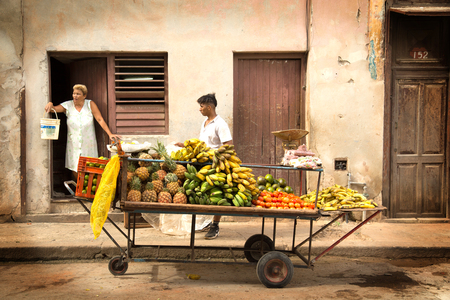 HAVANA-CUBA- DEC 5, 2018: Old woman and her son selling suits and veggies in the street of Centro Habana in Cubaのeditorial素材