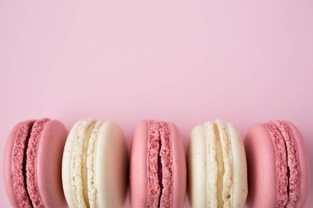 Row of traditional french macarons on pink backgroundの写真素材