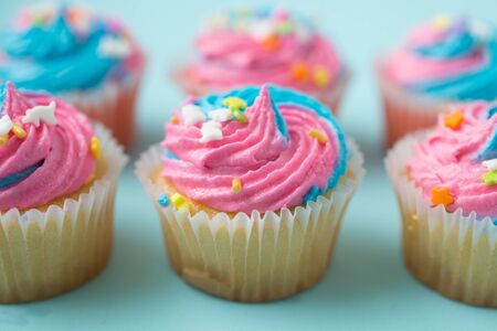 Cupcakes with blue and pink icing on a blueの写真素材