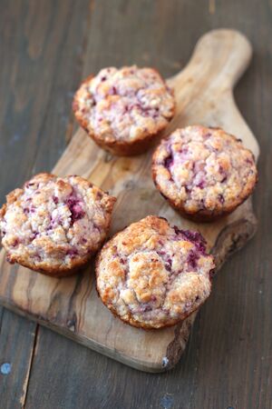 Homemade fruits muffins on a wooden boardの写真素材