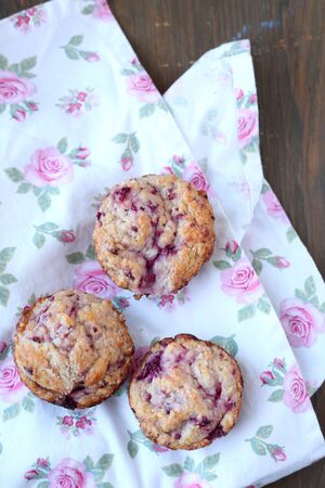 Homemade fruits muffins on a wooden pink flowered tableclothの写真素材