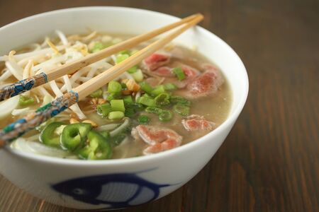 Asian noodle soup with beef, shives, onion, bean sprout and limeの写真素材