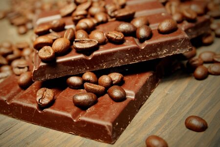 Dark chocolate with coffee beans on top on a woodenの写真素材