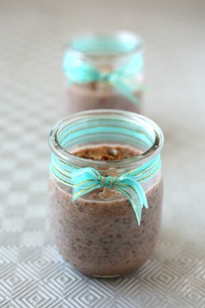 Healthy chocolate chia pudding with fresh nuts in a glass jarの写真素材