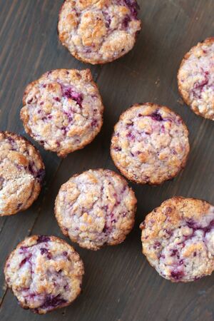 Homemade fresh and warm berries  muffins on a wooden backgroundの写真素材