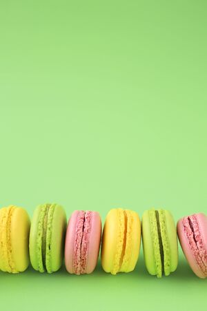 Row of traditional french macarons on green backgroundの写真素材