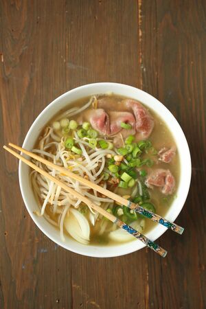Asian noodle soup with beef, shives, onion, bean sprout and limeの写真素材