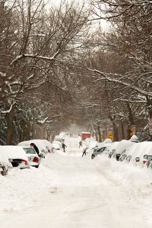 MONTREAL, CANADA, FEBRUARY 13, 2019: The street and cars are full of snow after a big snowstorm during winter season in Montreal, Quebec. People shoveling. More than 30 cm in 1 day on the city.の写真素材