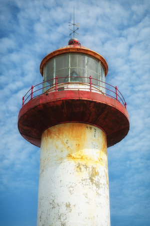 The red and white Cap Madeleine lighthouse in Gaspesie, Quebec, Canada in a blue skyの写真素材