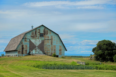 Wooden old turquoise with rust barn in a field in Kamouraska, Quebec, Canada.の写真素材