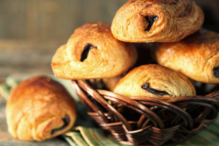 Warm and fresh french pastry name pain au chocolat in a rattan basket on a tableの写真素材