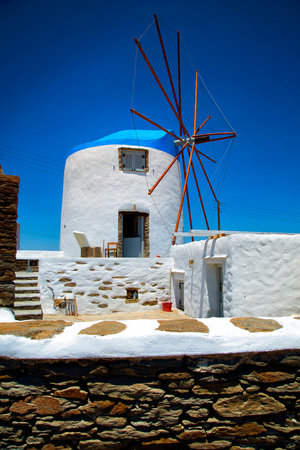 White windmill with blue rooftop in a blue sky in Greeceの写真素材