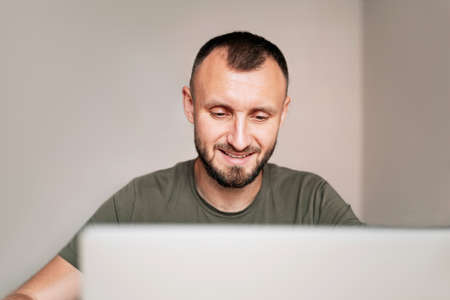 Portrait of freelancer at home. Young handsome man working on laptopの写真素材