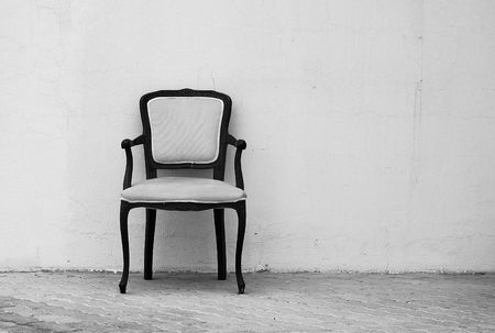 An empty chair by a wall の写真素材