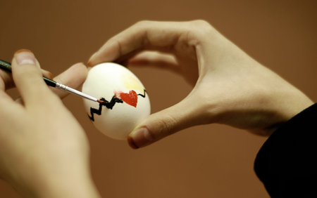 Hands painting a design on an eggの写真素材