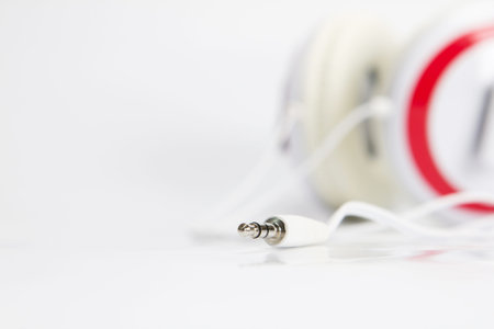 selective focus on audio plug of headphones on white background