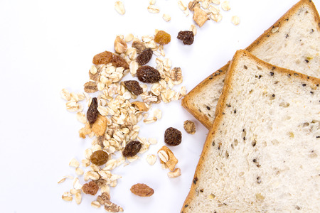 the cereal and black sesame bread with whole grain cereal flakes which mixed warming cinnamon , red skin apple , golden raisins and roasted hazelnuts on white backgroundの写真素材