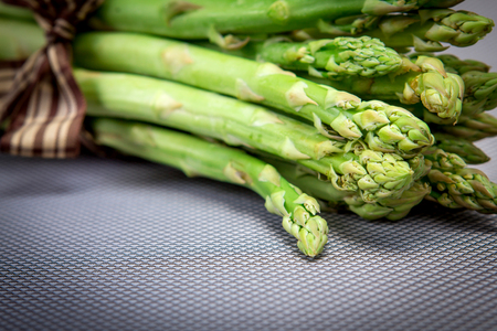 selective focus of close up Asparagus bind with brown ribbon on blue grey backgroundの写真素材