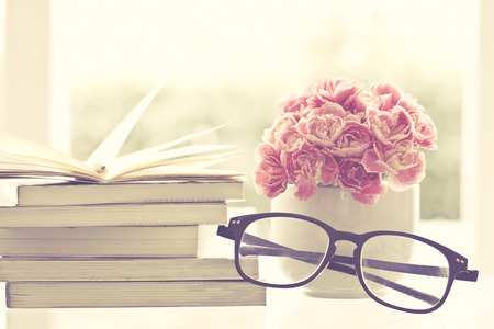 the fresh pink carnation flower with books backgroundの写真素材