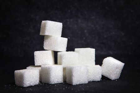 cloose up the white sugar cubes on black stone plate backgroundの写真素材