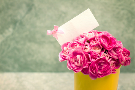 the Fresh pink carnation flower and blank card for copy space over stone plate backgroundの写真素材