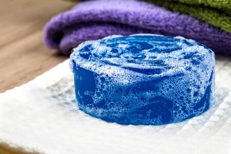 the natural soap bar and bubble with bath towel on wooden backgroundの写真素材