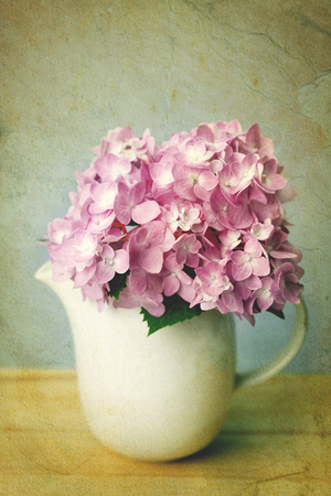 selective focus of the sweet purple  hydrangea flowers in white vase on wooden plate , vintage and still lifeの写真素材