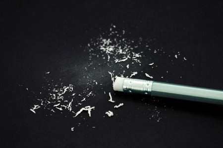 eraser of the end of silver wooden pencil with eraser dust on the black paperの写真素材