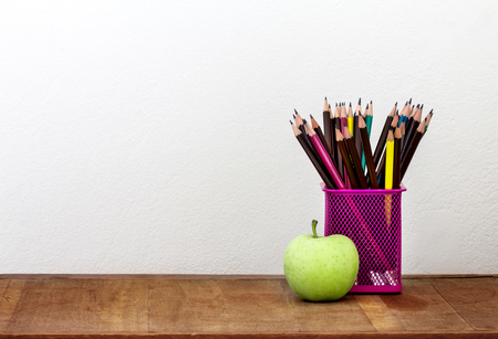 the green apple with pencil box on wooden table in concept of study or back to schoolの写真素材