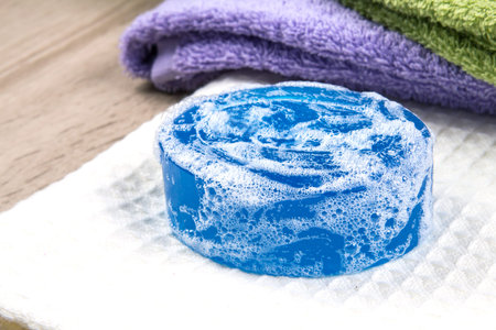 the natural soap bar and bubble with bath towel on wooden background
