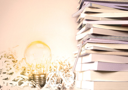 Close up book stacked  with the glowing light bulb background , creative education and learning conceptの写真素材
