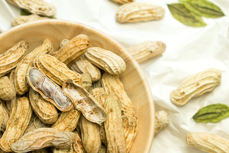close up the boiled peanuts in wooden cup on crumpled paper