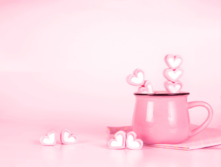 the marshmallow heart shape in cup on pink background with love conceptの写真素材