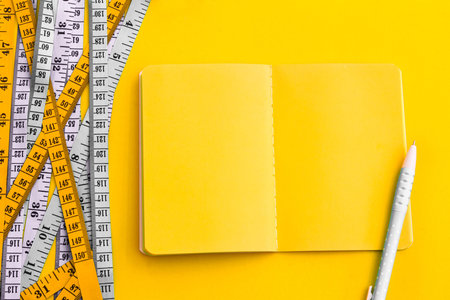 Diet control concept background. Colorful of Measuring tape on vibrant yellow color  background with...
